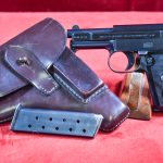 SOLD EXCEPTIONAL & VERY SCARCE MODEL 1910/34 MAUSER PISTOL, THE “BABY” MODEL 1934, 6.35mm (.25 AUTO), WITH RARE BLACK PLASTIC BANNER GRIP, FULL RIG! MINT CRISP!